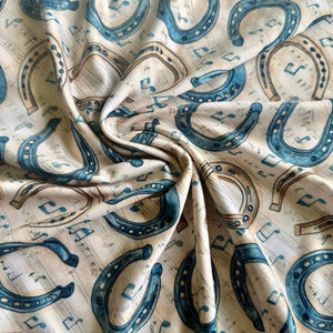 close up detail of the riding shirt horse shoe and music notes
