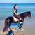 woman in equitation bear by the beach