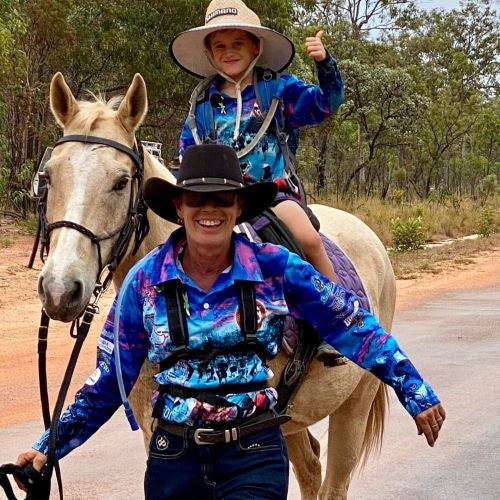 Marita Hird leading boy on horse at Conquer the Corrugations Mental Health Awareness Ride