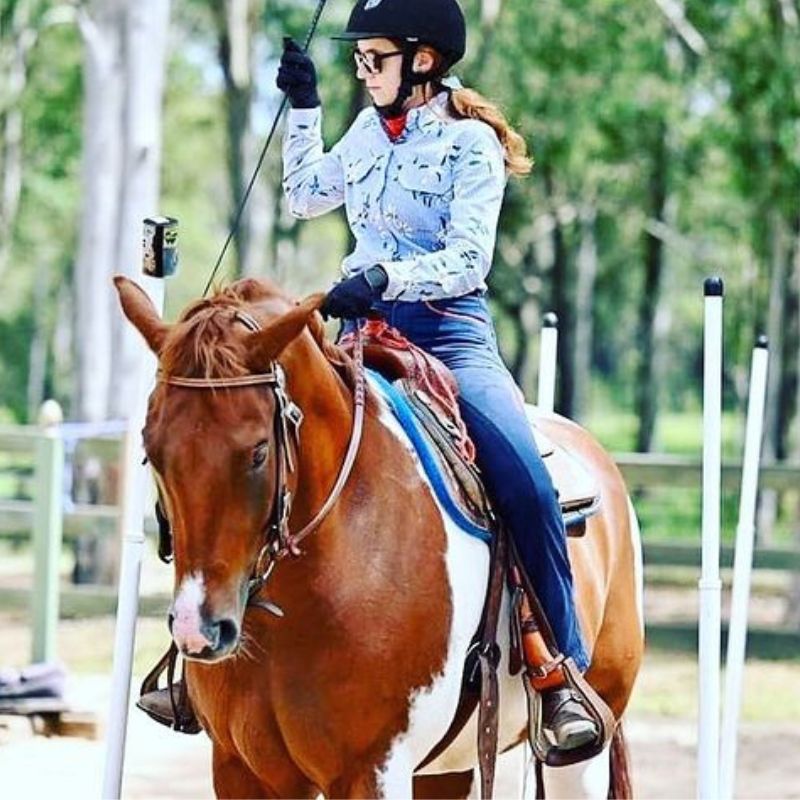 woman riding a brown horse wearing a limited edition style pants