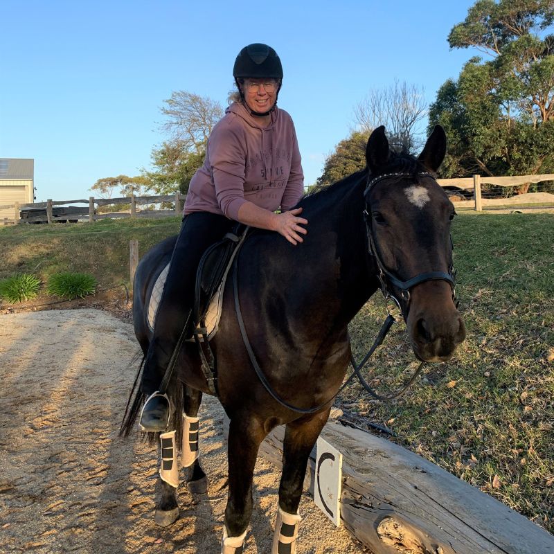 woman wearing a sweater riding a horse