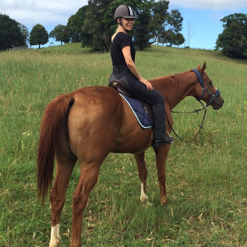 woman in black shirt riding a brown horse