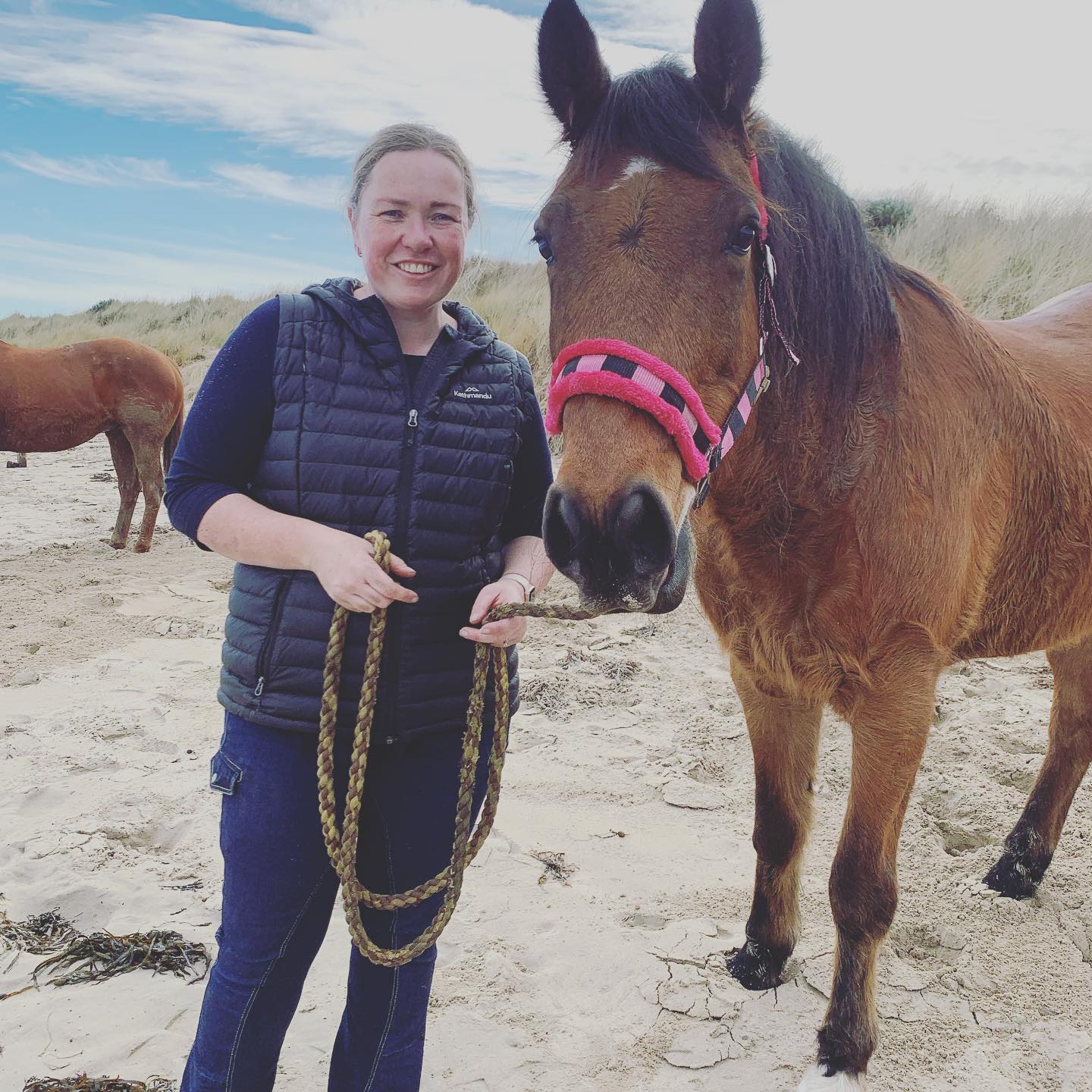 woman in horizon ride proud pants holding a horse