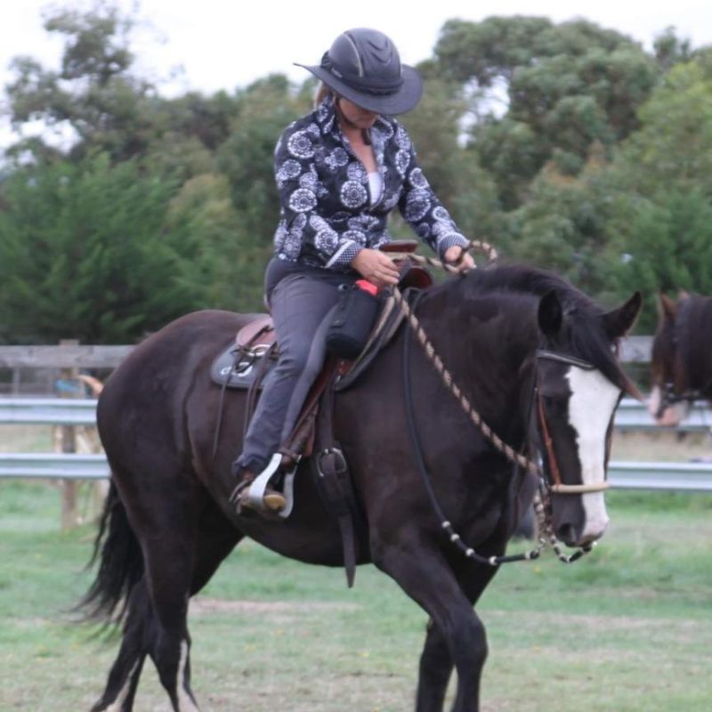woman in floral print shirt riding a horse