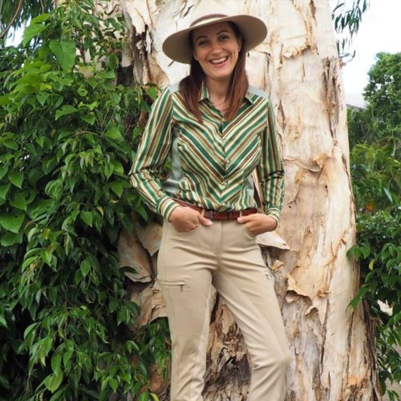 woman in green stripes standing in front of a trunk