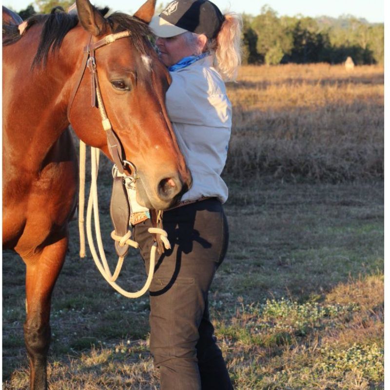 woman wearing white shirt fixing the horse