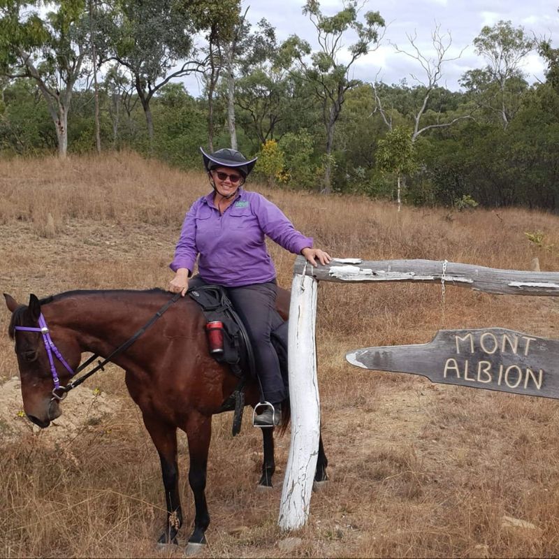 woman in purple beside a road sign