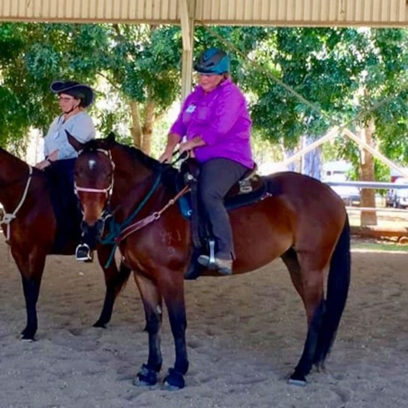 woman riding a horse in an arena