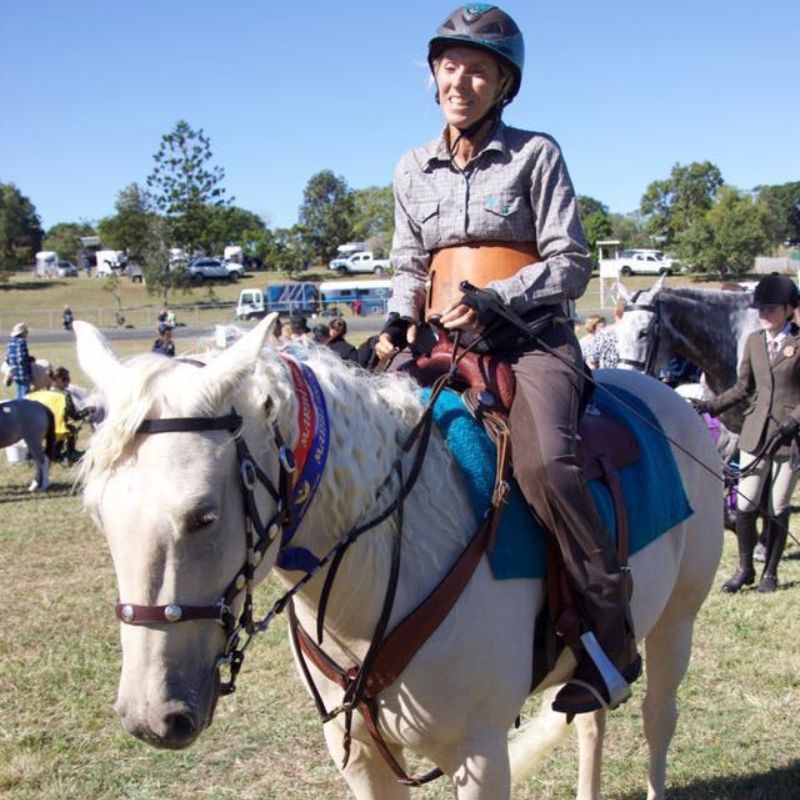 Woman riding a white horse