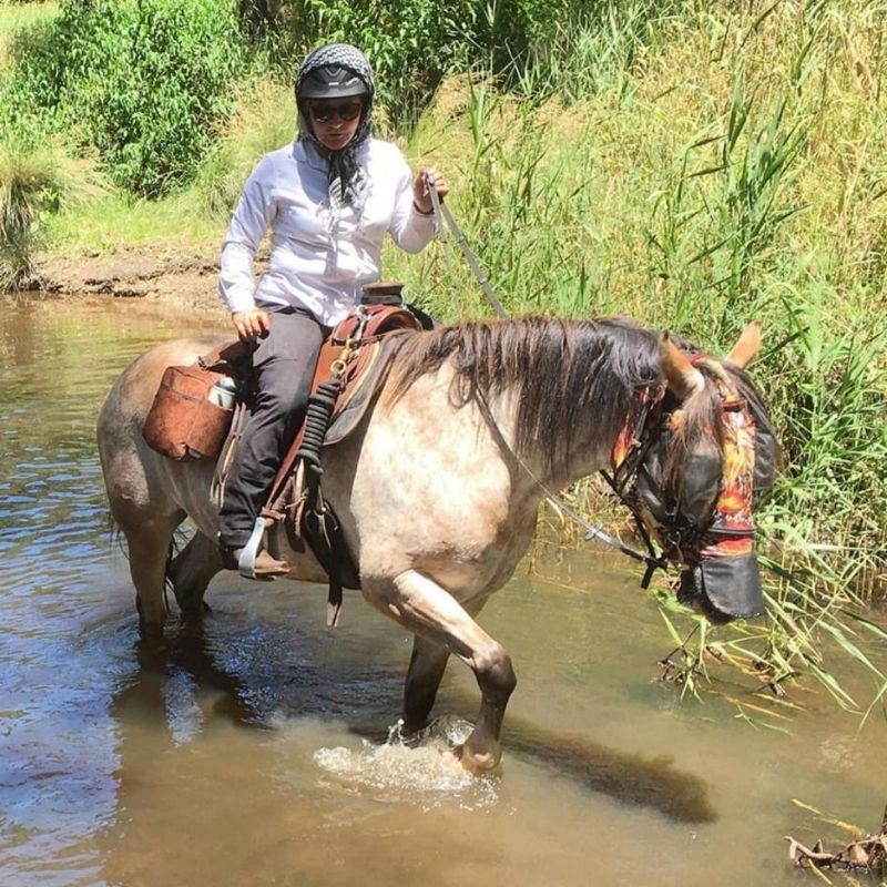 woamn in Trainers Horse Riding Pants crossing the river