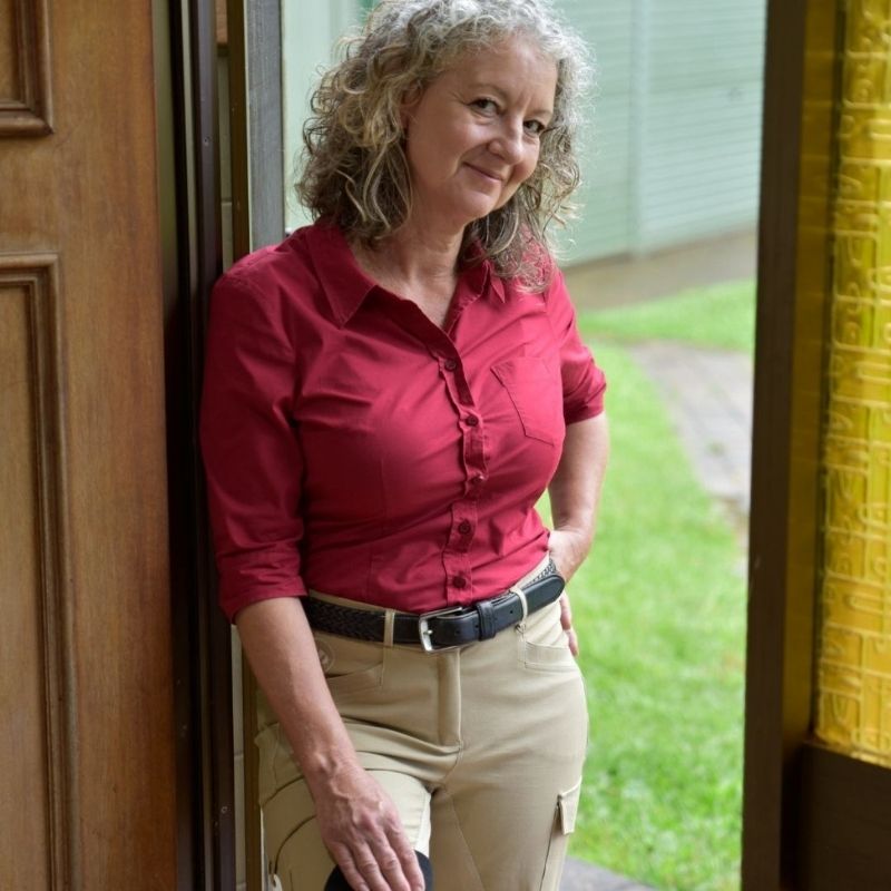 woamn standing wearing Trainers Horse Riding Pants and red top