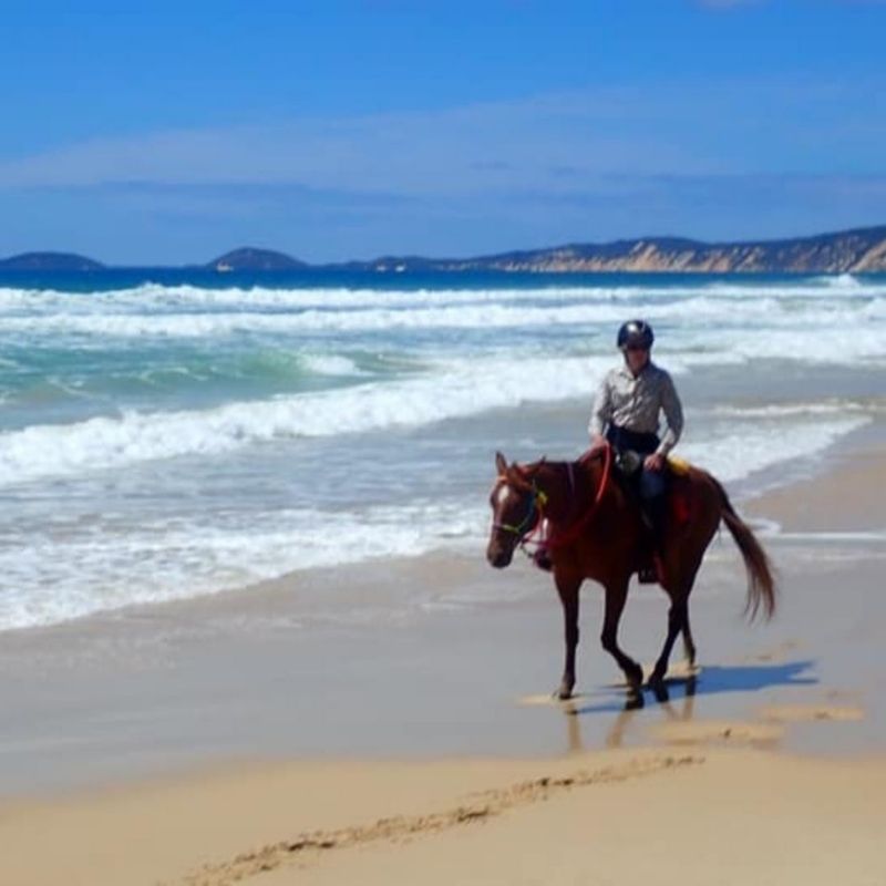 woman in equitation near the beach
