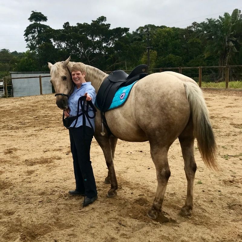woman in equitation standing beside the horse